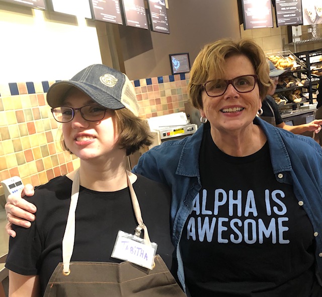 Alpha Group Workforce Development, employee smiling with woman in Alpha is Awesome shirt