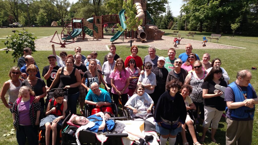 Alpha Group Integrated Adult Day, tons of smiles with a group together outside at a playground